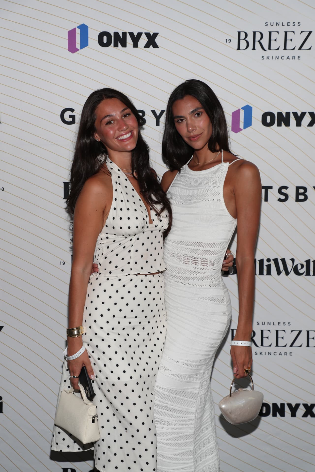 Two guests posing at the sponsor wall